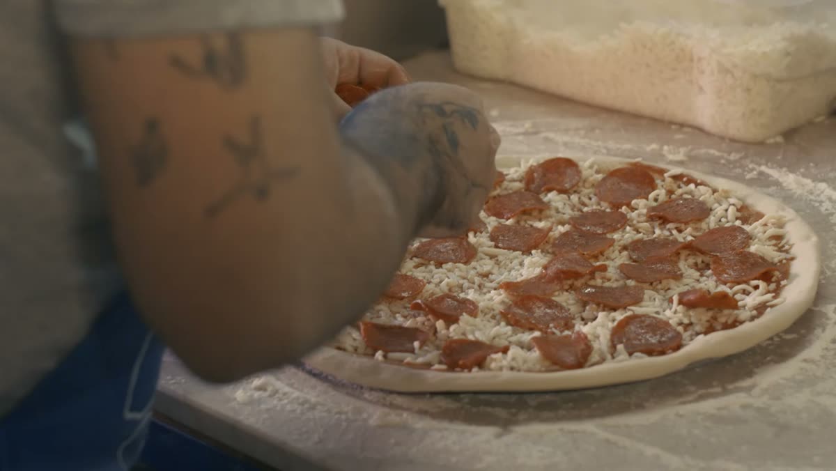 Garniture d'une pizza avant enfournement